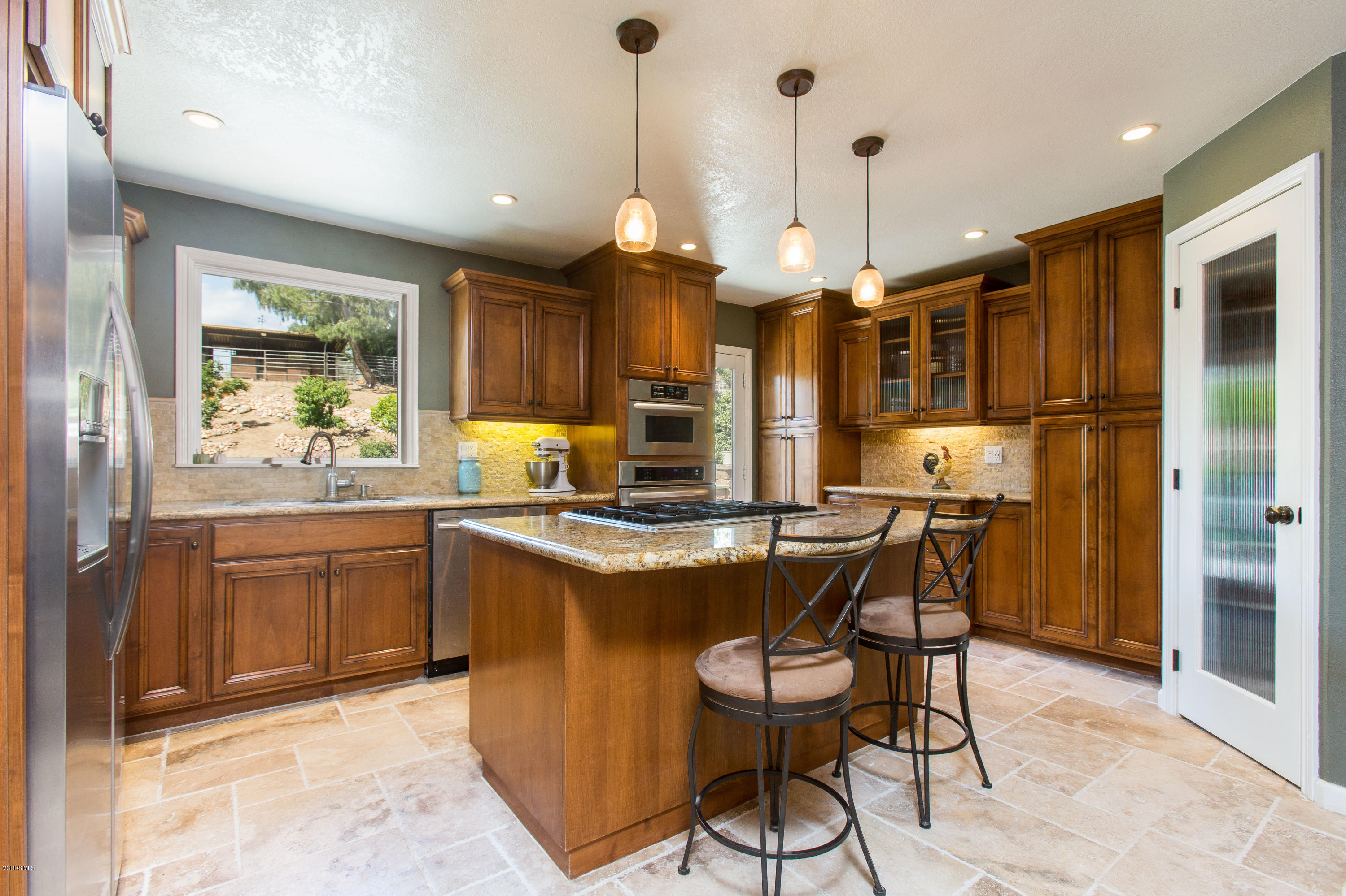 1177 Rambling Road Simi Valley, CA 93065 - Photo 11 of 56 a kitchen with stainless steel appliances granite countertop a stove a refrigerator a oven a sink with a dining table and chairs