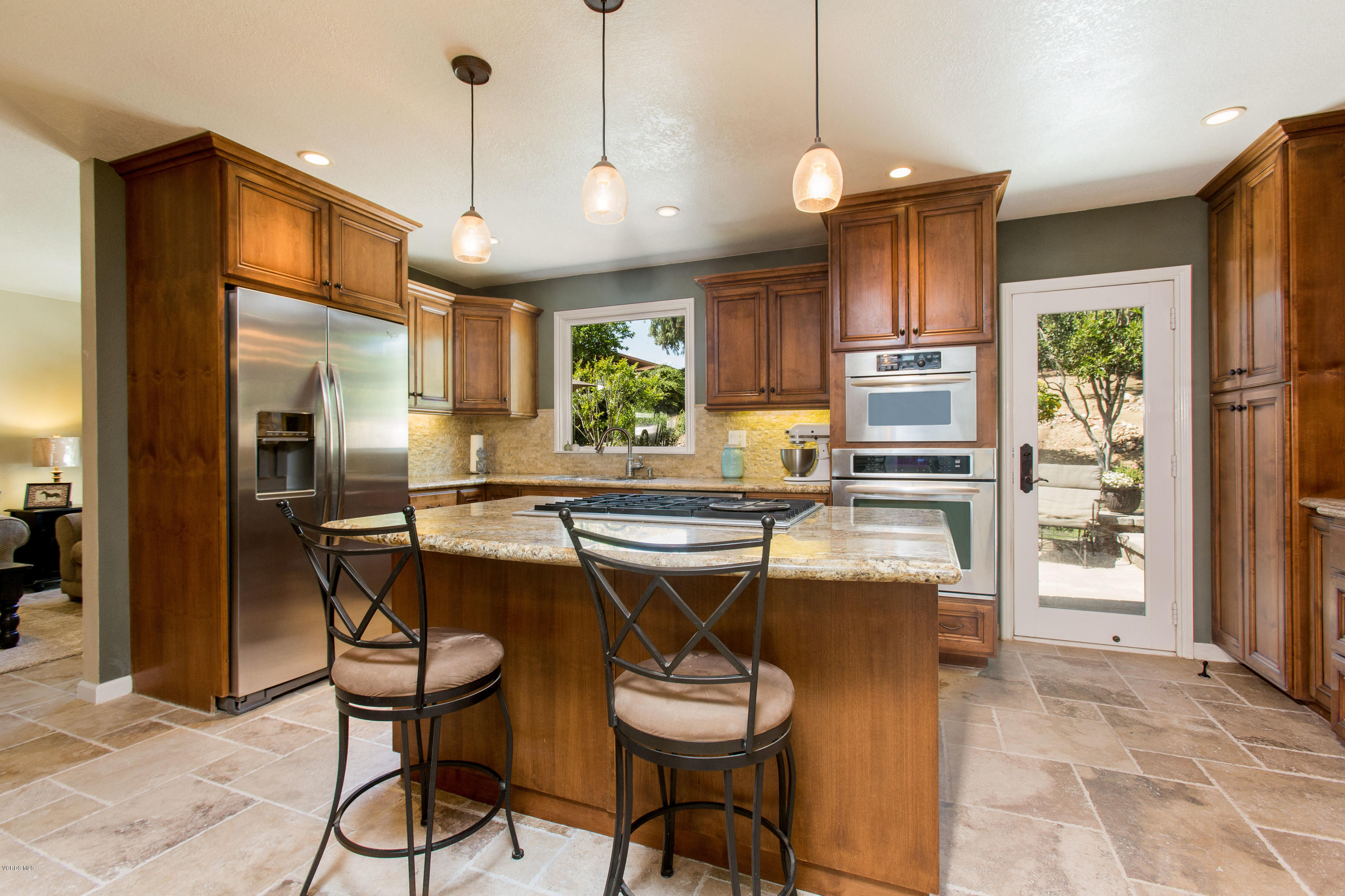 1177 Rambling Road Simi Valley, CA 93065 - Photo 10 of 56 a kitchen with stainless steel appliances granite countertop table chairs and a refrigerator