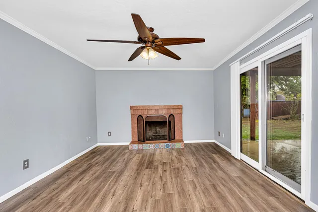an empty room with windows and fireplace