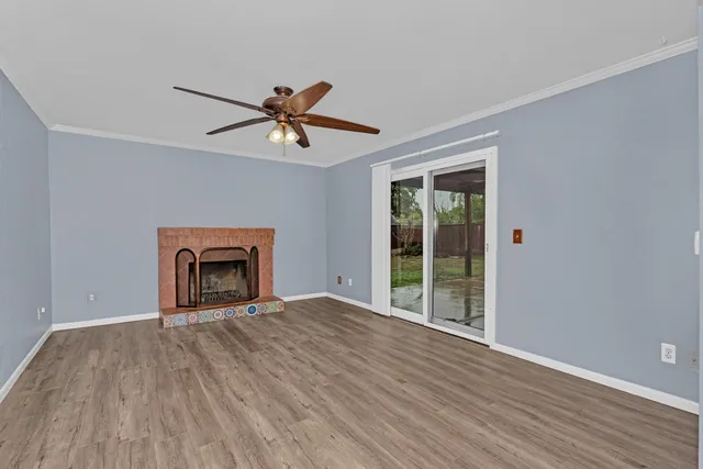 a view of a hallway with wooden floor and a bathroom