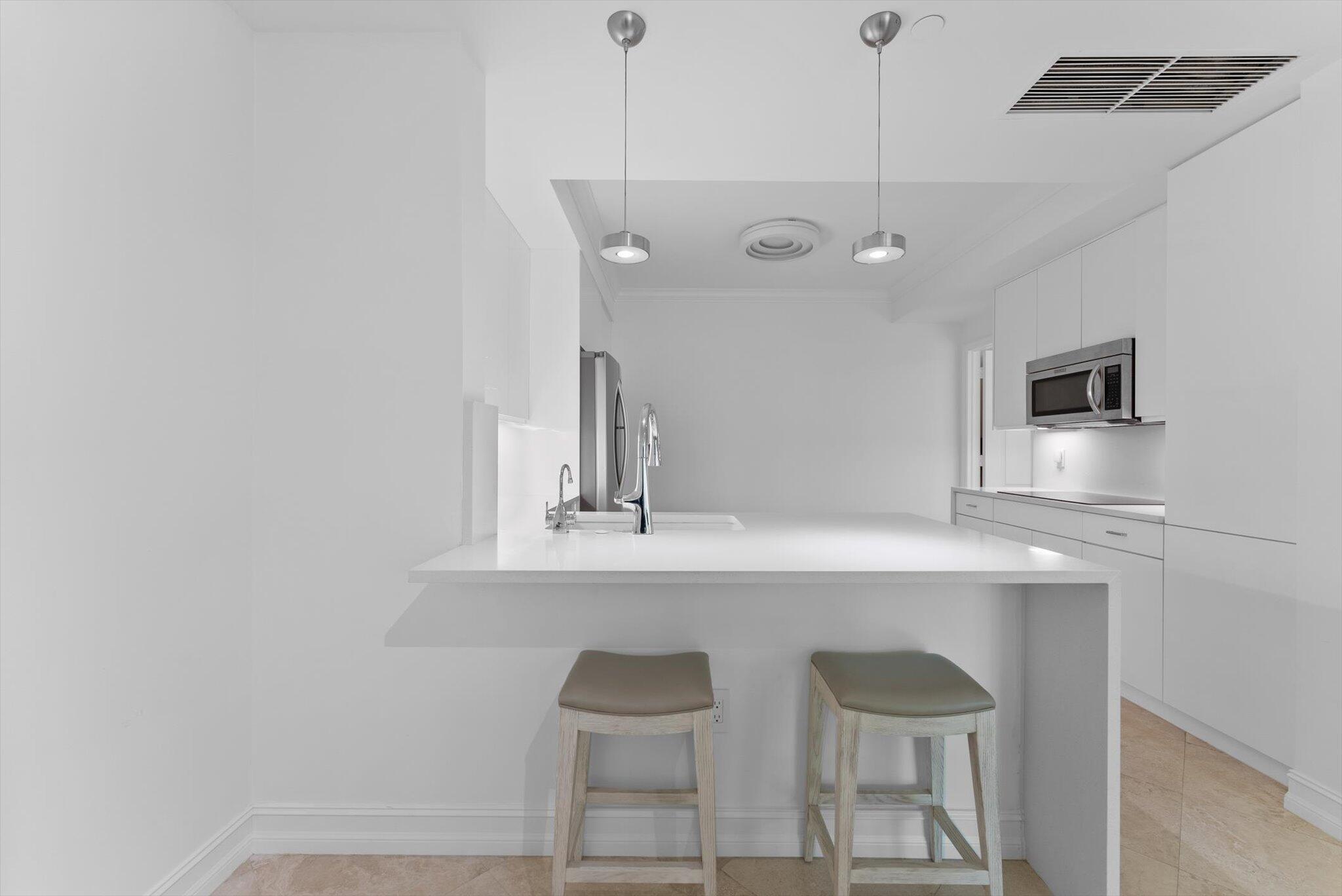 550 Southeast Mizner Boulevard, Unit B206 Boca Raton, FL 33432 - Photo 23 of 65 a kitchen with a sink and chairs