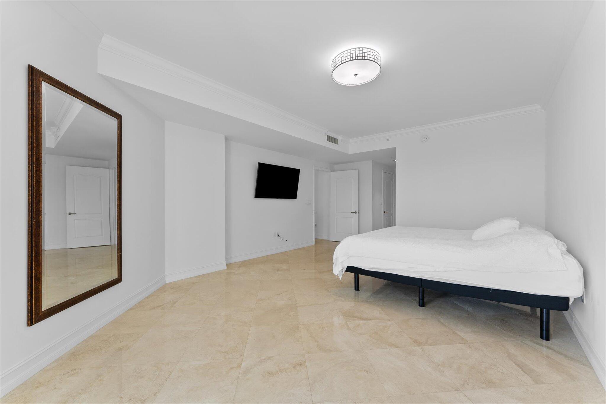 550 Southeast Mizner Boulevard, Unit B206 Boca Raton, FL 33432 - Photo 31 of 65 a room with a bed and a flat screen tv