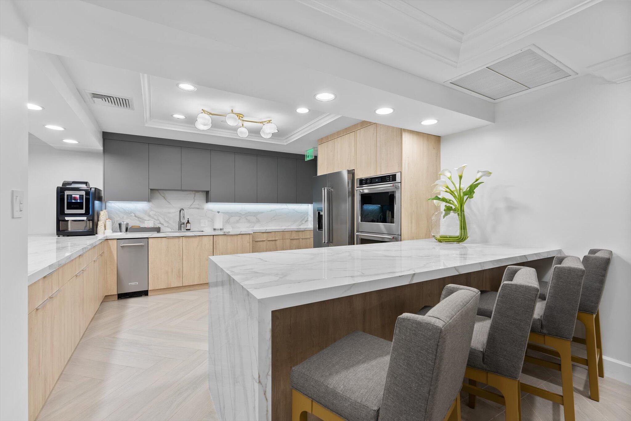 550 Southeast Mizner Boulevard, Unit B206 Boca Raton, FL 33432 - Photo 44 of 65 a kitchen with a table chairs sink and cabinets