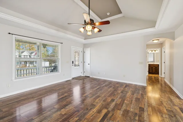a view of an empty room with a window and wooden floor