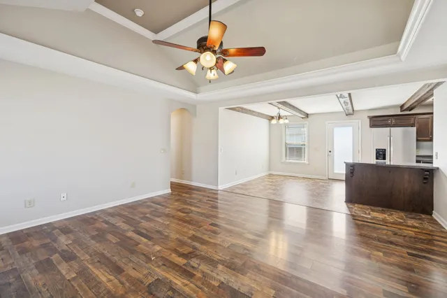 a view of a livingroom with a ceiling fan and wooden floor