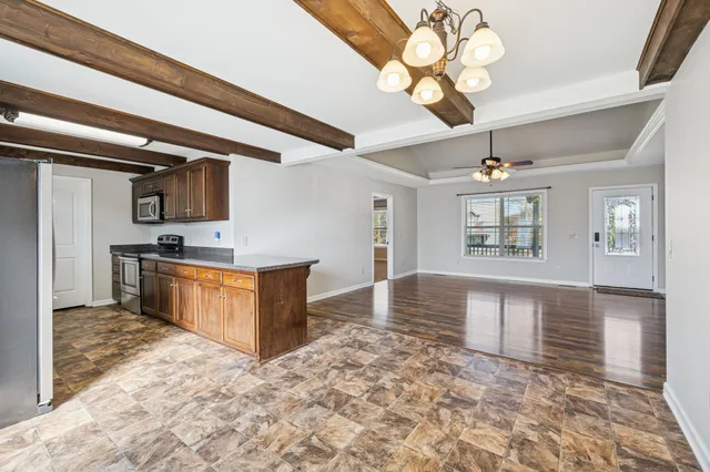 a kitchen with stainless steel appliances granite countertop a stove cabinets and chandelier