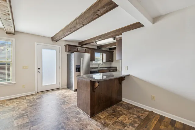 a view of kitchen with stainless steel appliances cabinets and outdoor space