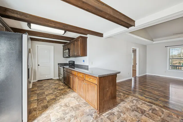 a large kitchen with stainless steel appliances granite countertop a sink and cabinets
