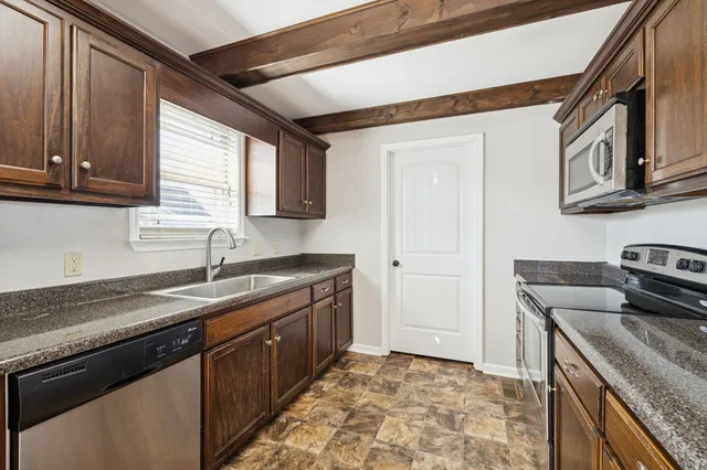 a kitchen with stainless steel appliances granite countertop a sink stove and cabinets