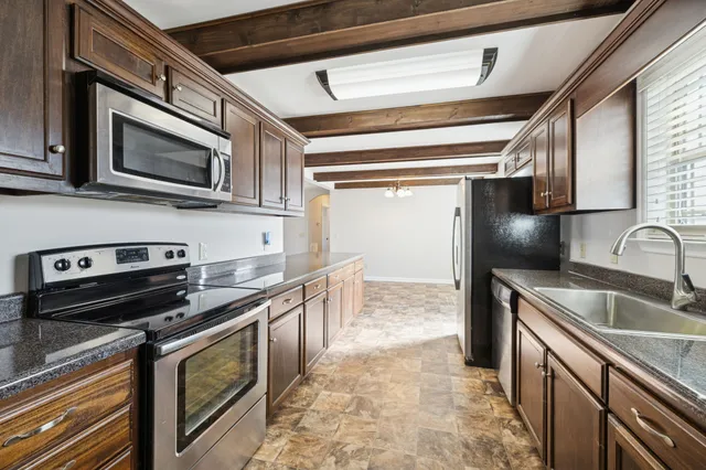 a kitchen with stainless steel appliances granite countertop a sink and a stove