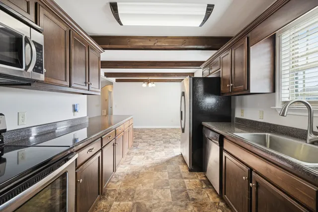 a kitchen with stainless steel appliances granite countertop a sink and a stove