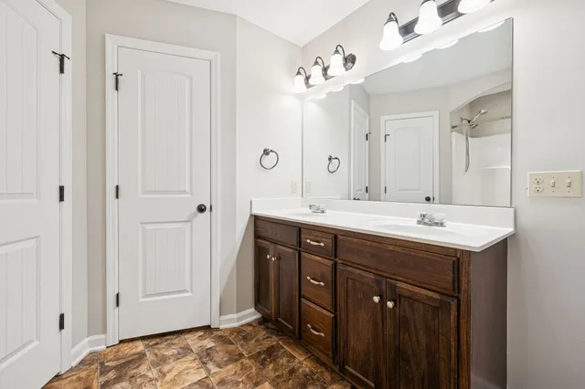 a spacious bathroom with a double vanity sink and mirror