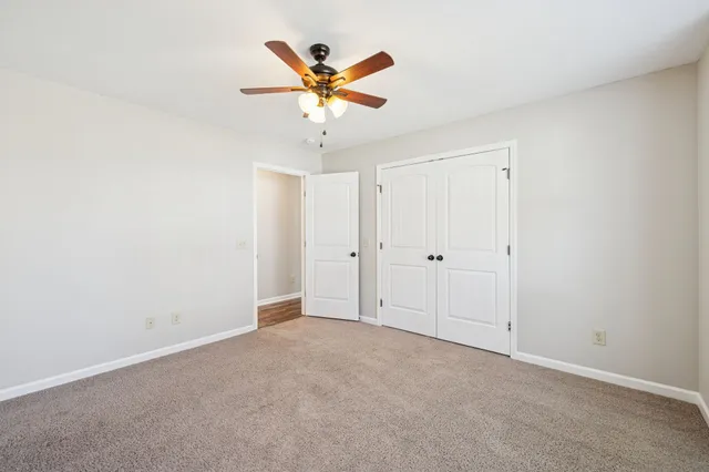 an empty room with a ceiling fan and a window