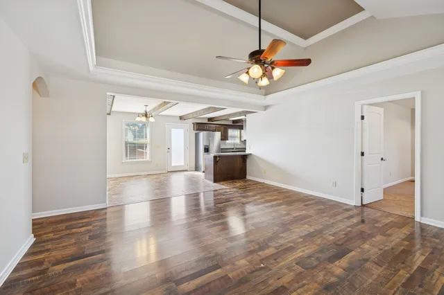 a view of a livingroom with a ceiling fan window and wooden floor