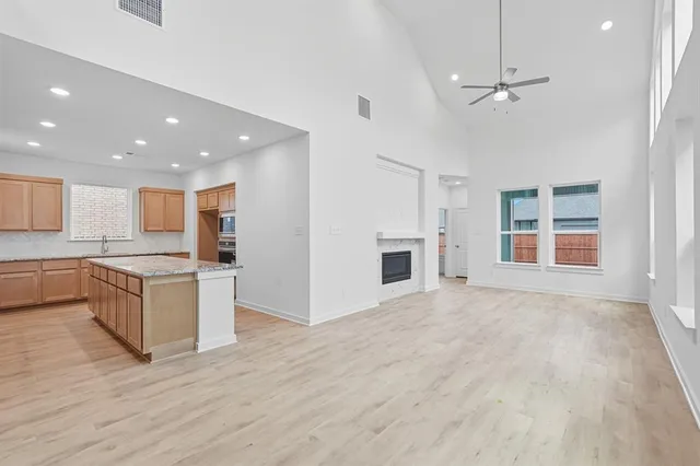 a large kitchen with granite countertop a large counter top and stainless steel appliances