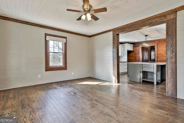 a kitchen with a stove a sink cabinets and wooden floor