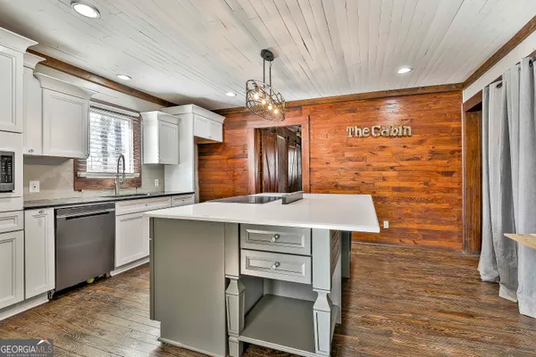 a kitchen with stainless steel appliances granite countertop cabinets a sink and a microwave
