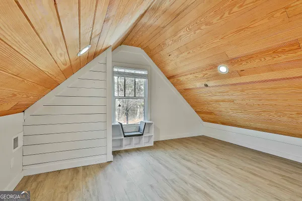a view of a big room with wooden floor and windows