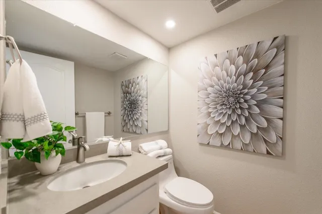 a bathroom with a granite countertop sink and a toilet