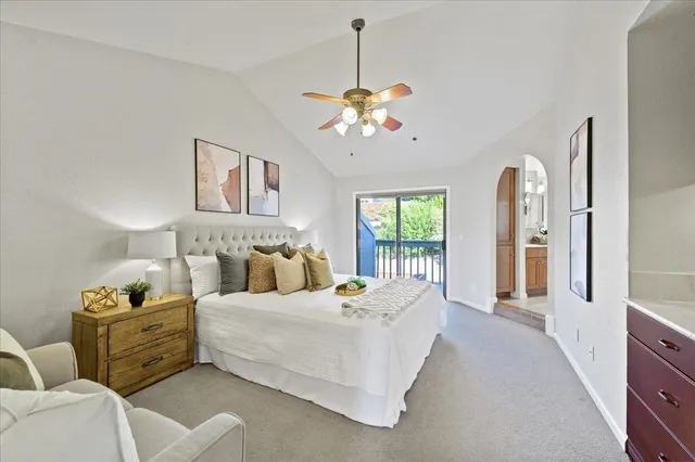 a bedroom with a large bed and ceiling fan