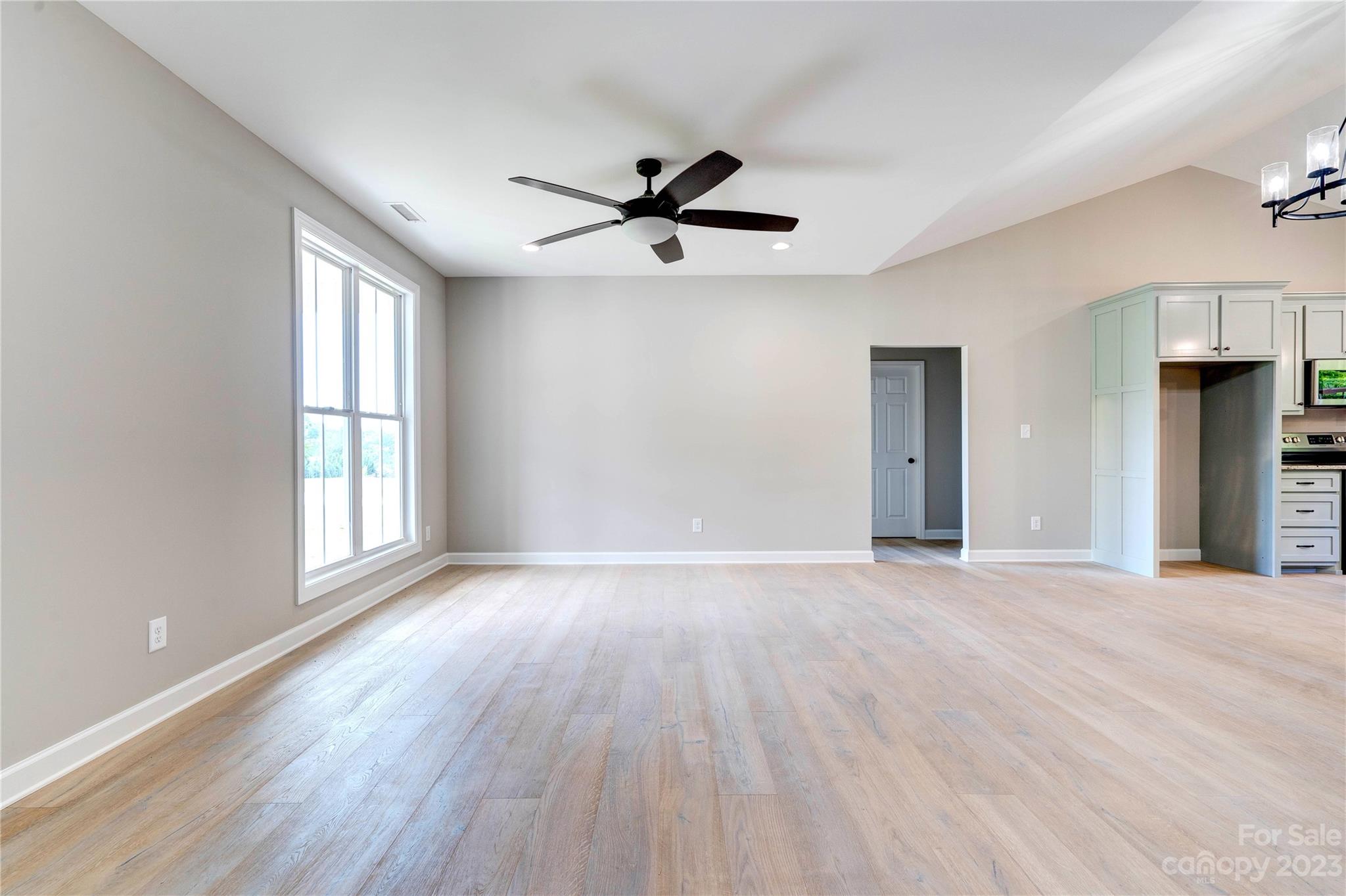 4326 Boulder Drive Morganton, NC 28655 - Photo 5 of 46 an empty room with wooden floor a ceiling fan and windows