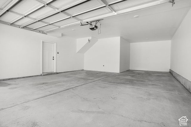 1631 West Century Lane, Unit B Mapleton, UT 84664 - Photo 20 of 23 Spacious garage with an overhead door, smooth concrete flooring, and a white entry door