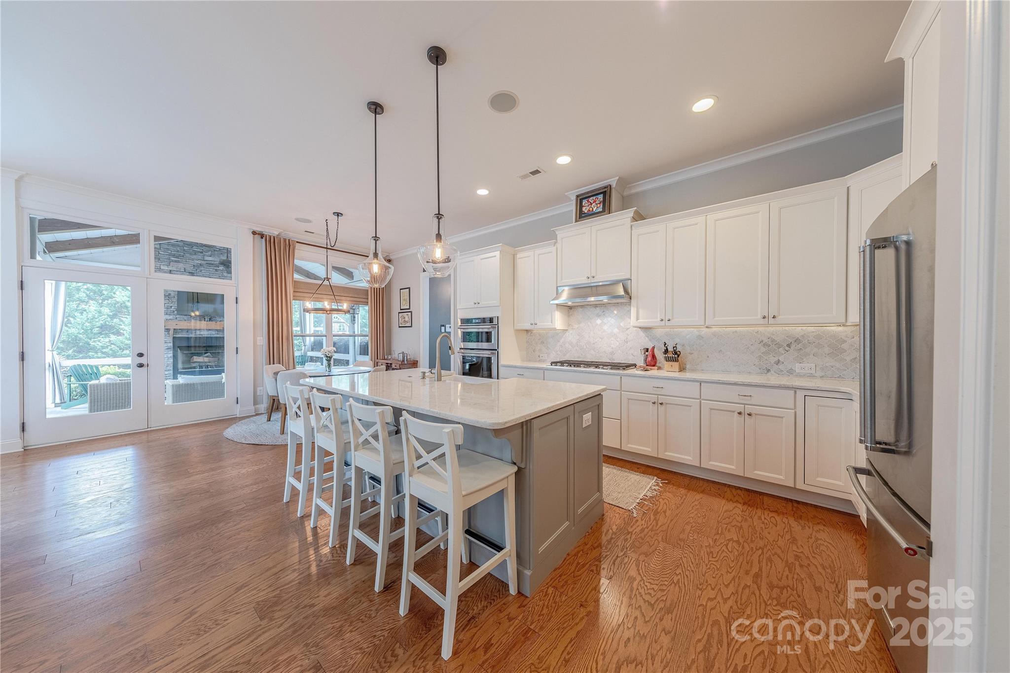 5256 Meadowcroft Way Fort Mill, SC 29708 - Photo 13 of 48 a kitchen with stainless steel appliances granite countertop a stove a refrigerator a kitchen island with a dining table and chairs