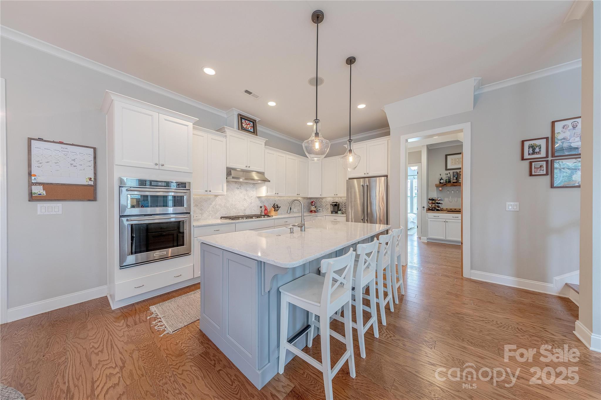 5256 Meadowcroft Way Fort Mill, SC 29708 - Photo 10 of 48 a kitchen with kitchen island granite countertop a refrigerator a stove a oven a sink a dining table and chairs with wooden floor