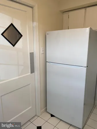 a view of a kitchen with white cabinets and white appliances