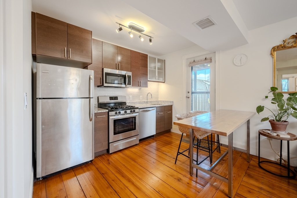 20 Porter Street, Unit 2 Boston, MA 02130 - Photo 1 of 35 a kitchen with stainless steel appliances a refrigerator a stove a sink cabinets and a dining table