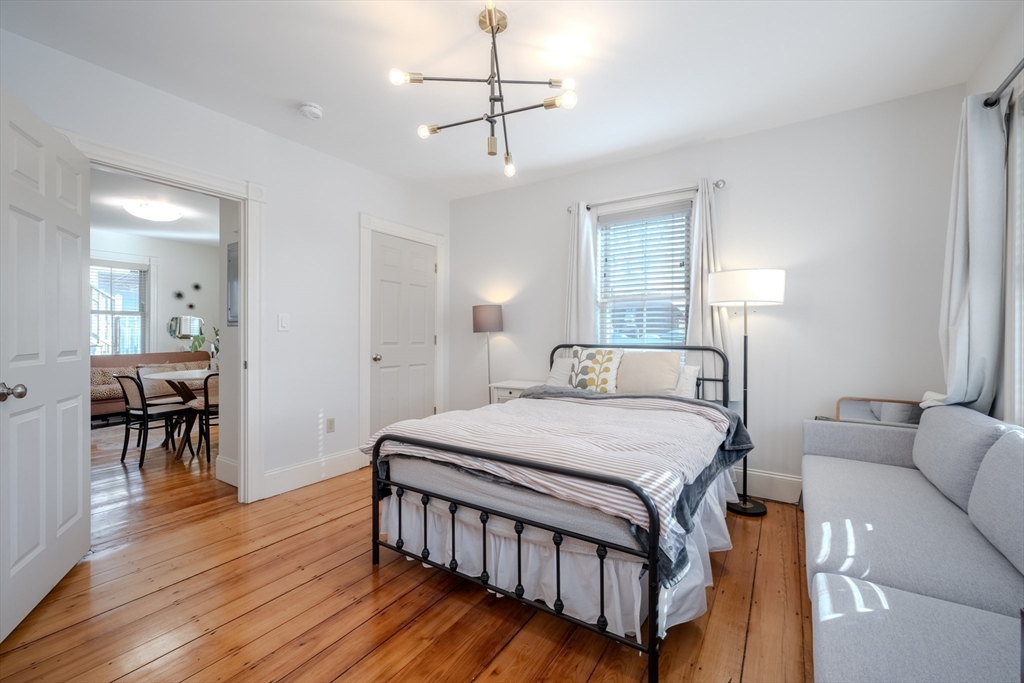 20 Porter Street, Unit 2 Boston, MA 02130 - Photo 22 of 35 a bedroom with a bed wooden floor and a table