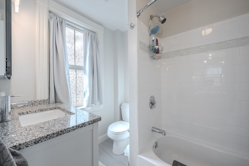 20 Porter Street, Unit 2 Boston, MA 02130 - Photo 29 of 35 a bathroom with a granite countertop sink a toilet and shower