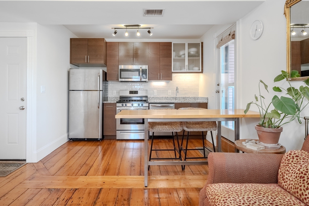 20 Porter Street, Unit 2 Boston, MA 02130 - Photo 8 of 35 a living room with stainless steel appliances kitchen island granite countertop furniture a rug and a window