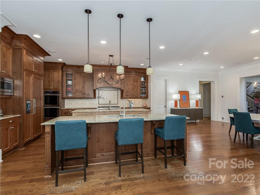 14140 Claysparrow Road Charlotte, NC 28278 - Photo 17 of 48 a dining hall with stainless steel appliances kitchen island granite countertop a table chairs and a living room view