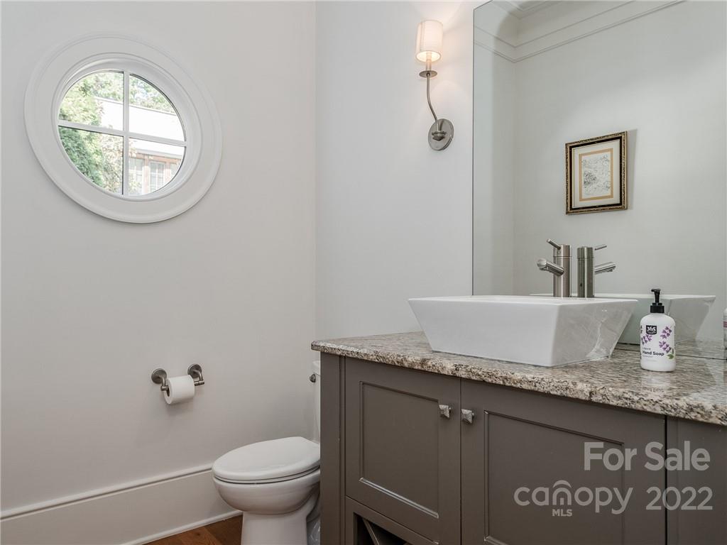 14140 Claysparrow Road Charlotte, NC 28278 - Photo 18 of 48 a bathroom with a granite countertop toilet a sink and a mirror