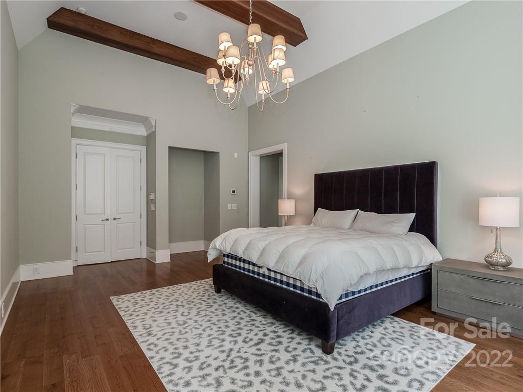 14140 Claysparrow Road Charlotte, NC 28278 - Photo 24 of 48 a bedroom with a large bed and a chandelier