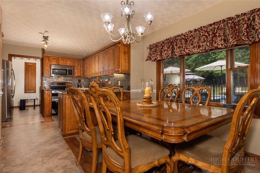 1335 Shingle Gap Road Purlear, NC 28665 - Photo 17 of 49 a view of a dining room with furniture a chandelier and kitchen view