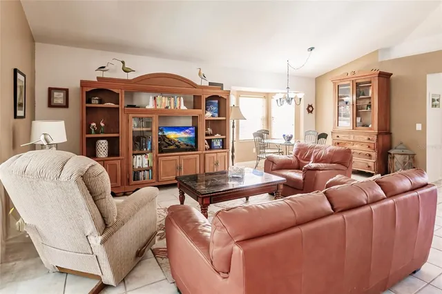 a living room with furniture a flat screen tv and a floor to ceiling window