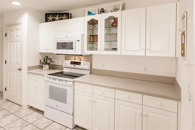 a kitchen with white cabinets and white appliances