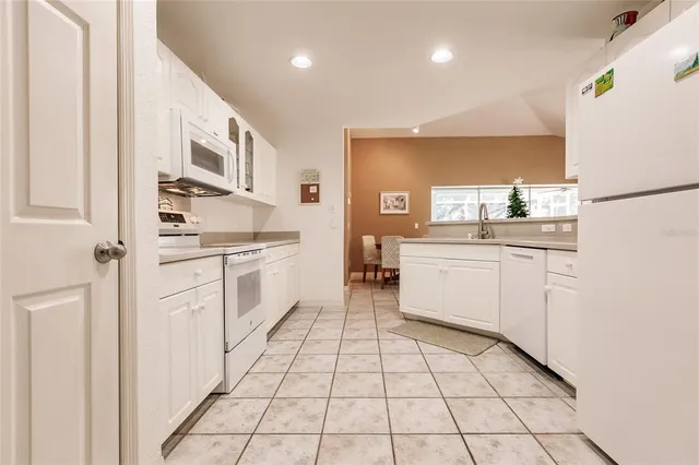 a kitchen with white cabinets a sink appliances and cabinets