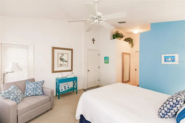 a bedroom with a bed couch and a chandelier