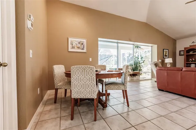 a dining room with furniture and a floor to ceiling window