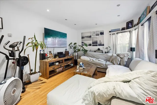 a living room with furniture a flat screen tv and a window