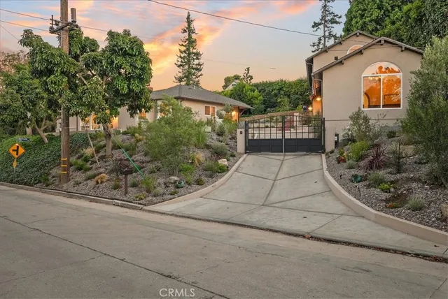 a front view of a house with a yard and potted plants