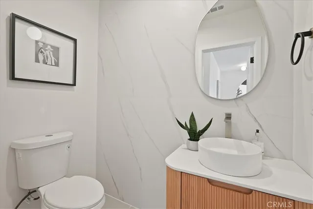 a bathroom with a sink a toilet a mirror and shower