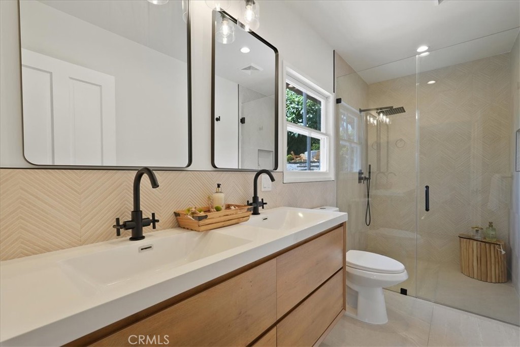 7404 Woodrow Wilson Drive Los Angeles, CA 90046 - Photo 24 of 57 a bathroom with a sink a toilet a mirror and shower
