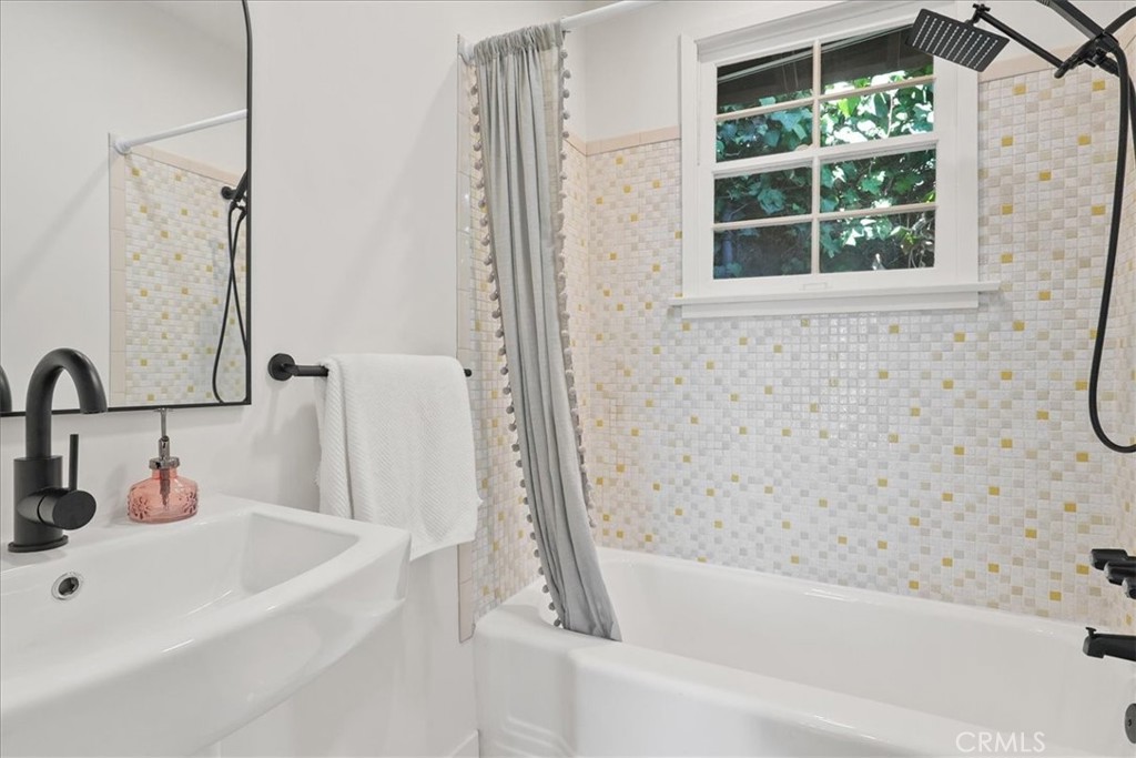7404 Woodrow Wilson Drive Los Angeles, CA 90046 - Photo 39 of 57 a bathroom with a tub sink and a window