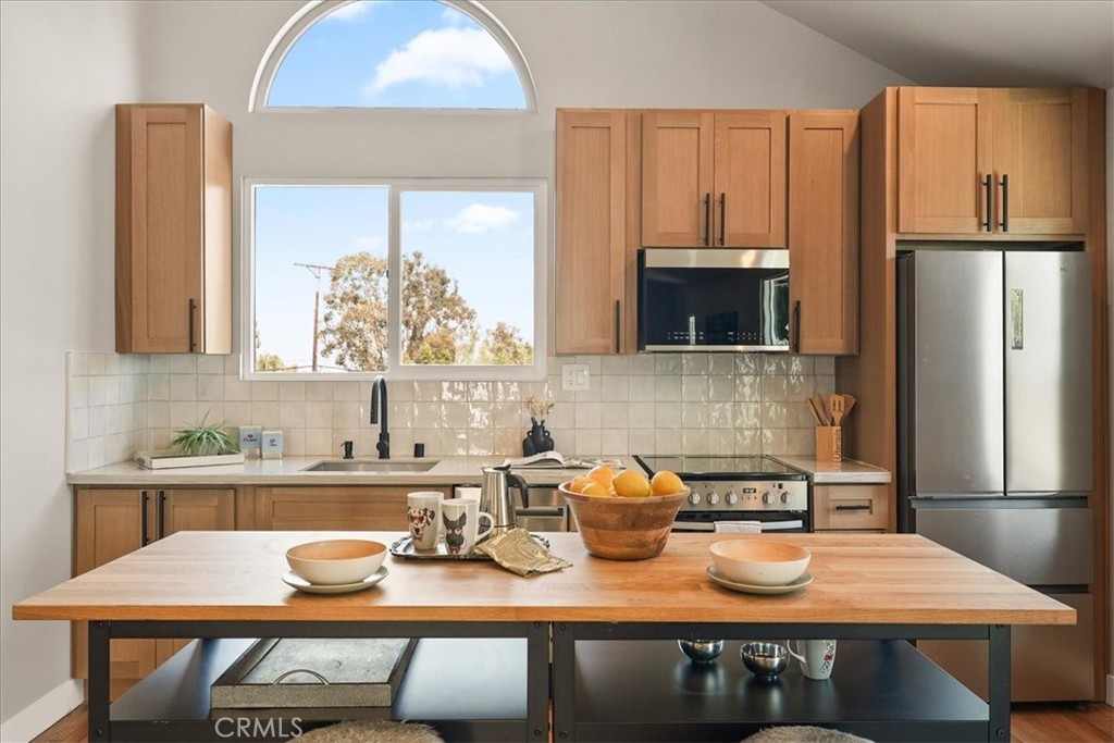 7404 Woodrow Wilson Drive Los Angeles, CA 90046 - Photo 45 of 57 a kitchen with a table chairs sink and refrigerator