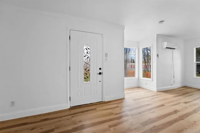 a view of an empty room with wooden floor