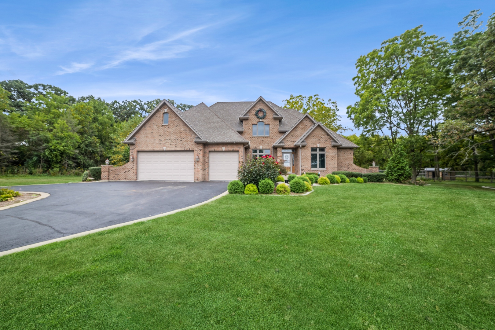 a front view of a house with a yard and trees
